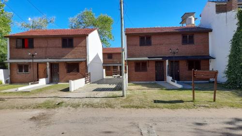 una vecchia casa di mattoni con un edificio bianco di Ensueños del mar a Las Toninas