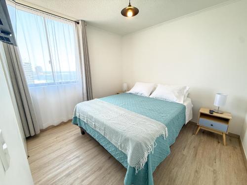 a bedroom with a bed and a large window at Departamento cerca de Cavancha Estacionamiento incluido in Iquique