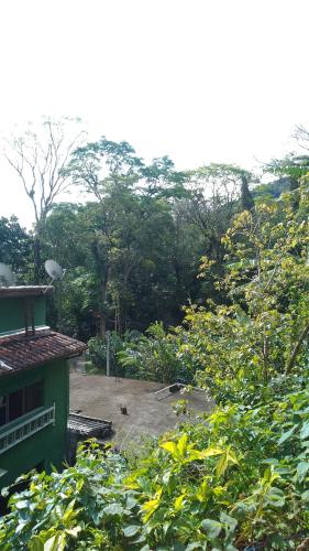 Blick auf einen Garten mit Bäumen und ein Gebäude in der Unterkunft Chalé toque toque pequeno in São Sebastião