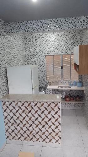 eine Küche mit Theke und Kühlschrank in der Unterkunft Chalé toque toque pequeno in São Sebastião