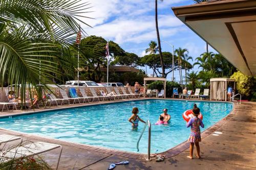 a group of children playing in a swimming pool at Affordable Vacation Accommodations in Maui at the Kihei Kai Nani Resort in Kihei