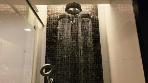 Beautiful Pool View Studio in Kata في شاطئ كاتا: دش مع ماء يخرج من الحائط