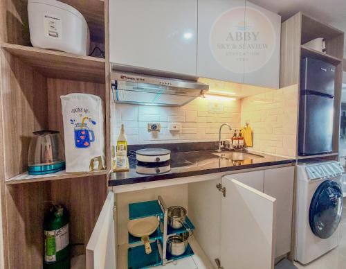 een kleine keuken met een spoelbak en een fornuis bij Abby Sky&Seaview Staycation Cebu in Mandaue-stad