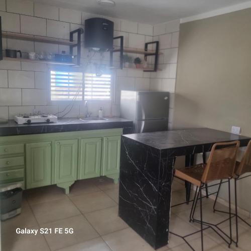 a kitchen with green cabinets and a black counter top at El amparo in San Luis