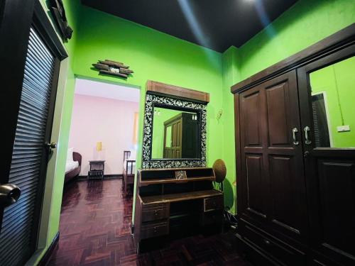 a green room with a mirror on the wall at Lanna Boutique Resort Chiang Mai in Chiang Mai