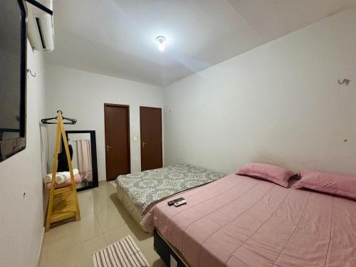 a bedroom with a bed with a pink blanket at Temporada AK Freitas in Parnaíba