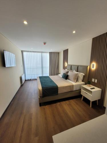 una camera con un grande letto e un comodino di Refugio del Turista a Tupiza