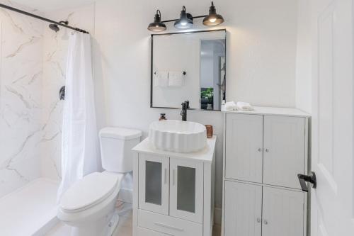 Un baño blanco con lavabo e inodoro. en Florida Paradyse ll 5 min downtown Cozy Modern, en Fort Myers