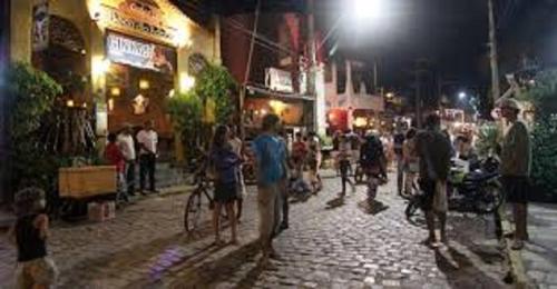 a group of people standing on a street at night at Sonia Flats Pipa's Bay - Flat 211 in Pipa