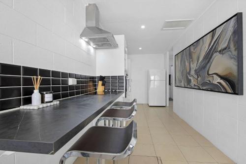 The Coastal Escape - Games & Vibes في غولد كوست: غرفة انتظار بها صف من المقاعد في الحمام