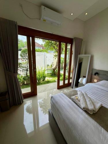 a bedroom with a bed and a large window at Peaceful Tropical Villa with private pool in Panji