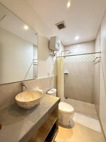 a bathroom with a sink and a toilet and a mirror at Peaceful Tropical Villa with private pool in Panji