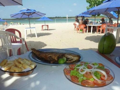 a table with a plate of food on the beach at Sonia Flats Pipa's Bay - Flat 211 in Pipa