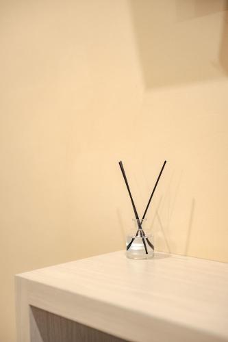 a glass holder with two sticks in it on a table at Treerat Bangtao House in Ban Hua Phrong