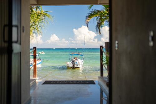 a door to a house with a boat in the water at Ocean Plaza by Zamá Homes in Playa del Carmen
