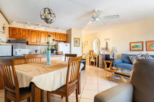 a kitchen and living room with a table and a couch at Affordable Vacation Accommodations in Maui at the Kihei Kai Nani Resort in Kihei