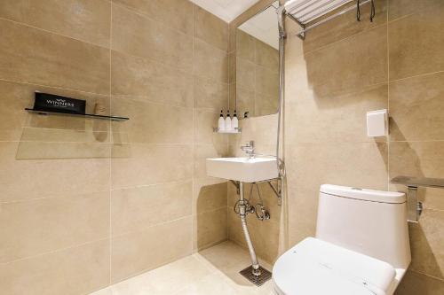 un baño con inodoro y lavabo en Winners Hotel, en Gangneung