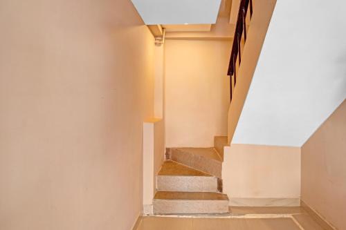 a staircase in a house with a white wall at Hotel O Ramya Inn in Warangal