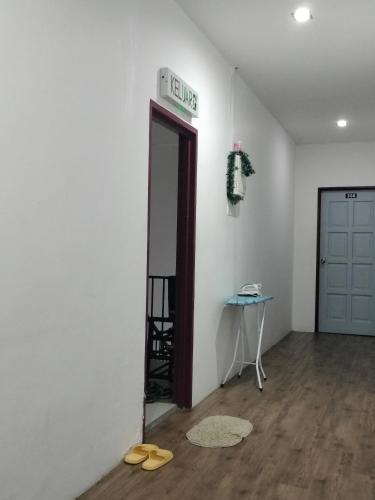 a room with a door and a table with sandals on the floor at BENUTHOMEStay in Benut
