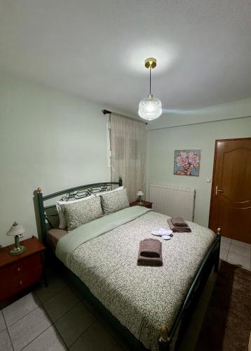 a bedroom with a large bed and a chandelier at Tzelak Village House in Palaiomonástiron