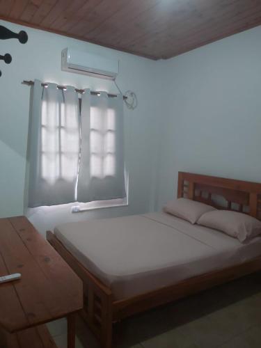 a bedroom with a large bed with a window at DON MIGUEL DEPARTAMENTOS in Puerto Iguazú