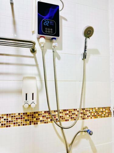 a shower with a digital clock on the wall at TJ PATONG HOSTEL - Prime Location by OTOP Market & Sea in Patong Beach