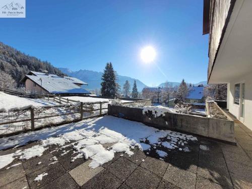eine schneebedeckte Terrasse mit Zaun und Bergen in der Unterkunft Apartments in Bad Mitterndorf - Steiermark 41123 in Bad Mitterndorf