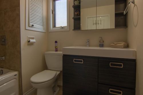 a bathroom with a toilet and a sink and a mirror at Cozy bungalow near Montreal and shops in Longueuil