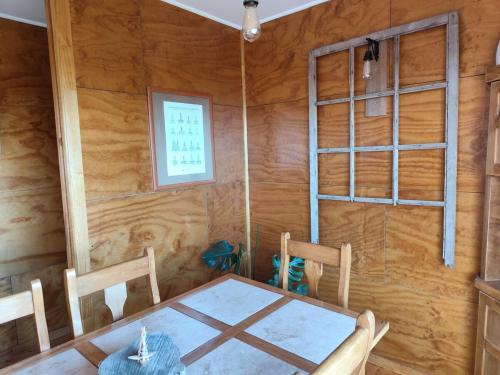 San JoséWaiwén Casa Chilota的一间有桌子、椅子和窗户的餐厅