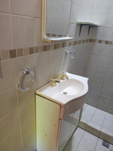 a bathroom with a sink and a mirror at Complejo Fresia in Mina Clavero