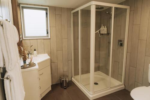 una ducha con puerta de cristal en un baño en Raglan Rural Retreats - Rimu Tent, en Raglan