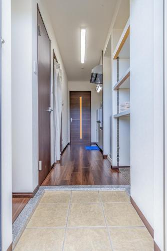 a hallway with wooden floors and white walls at オーシャンビュー窓から見える景色を思い出に The琉球タワー10F in Yonabaru