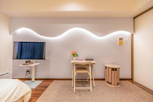a bedroom with a bed and a table and a tv at オーシャンビュー窓から見える景色を思い出に The琉球タワー10F in Yonabaru