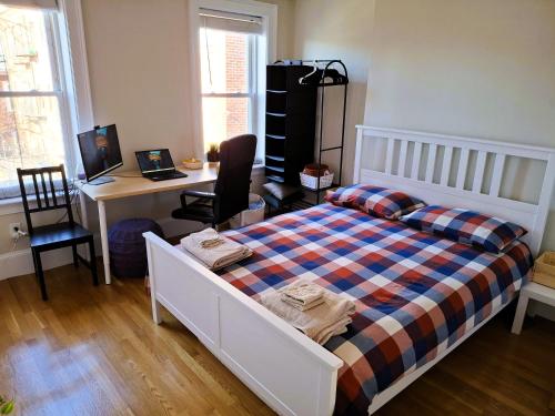 a bedroom with a bed and a desk with a computer at Homestay in South Boston in Boston