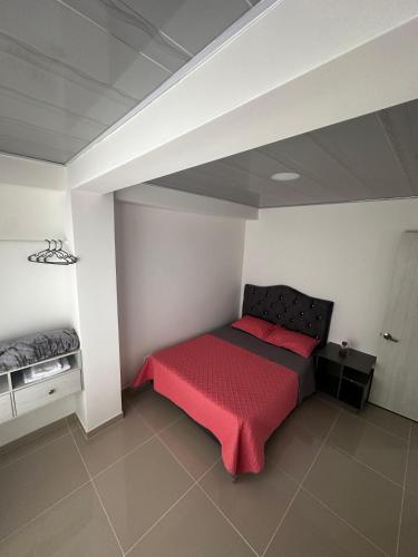 a bedroom with a bed with a red blanket at 302 Villamaria in Pereira