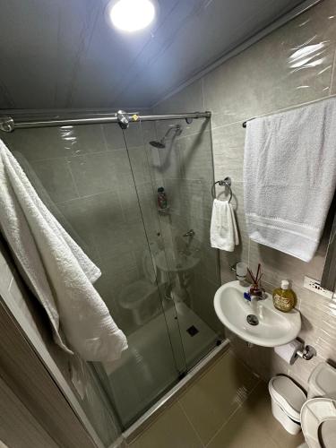 a bathroom with a glass shower and a sink at 302 Villamaria in Pereira