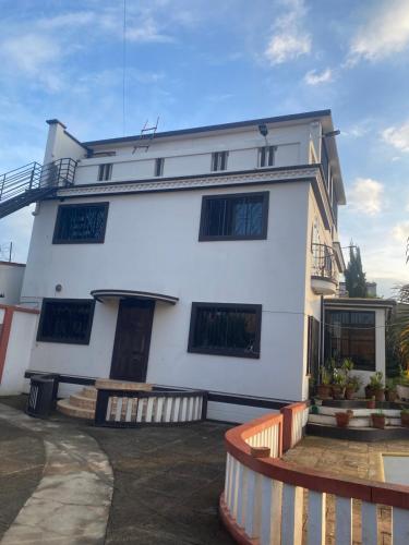 een wit gebouw met een hek ervoor bij 米帝亚 in Mandriankeniheny