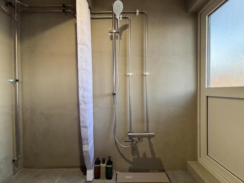 a shower in a bathroom with a shower curtain at Toya Tiny Cabin 洞爺タイニーキャビン in Lake Toya