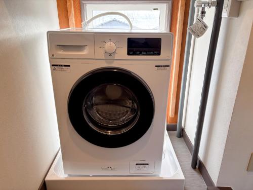 a washing machine in a room with a window at Toya Tiny Cabin in Lake Toya