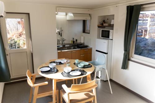 a small kitchen with a table and chairs in a room at Toya Tiny Cabin in Lake Toya