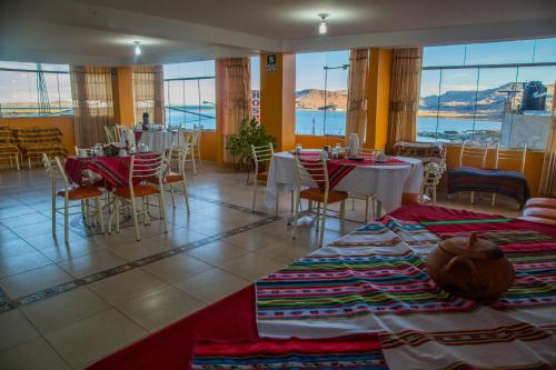 een restaurant met tafels en stoelen en een kamer met ramen bij Wisny Inn in Puno