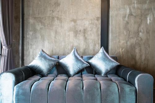 Un sofá azul con tres almohadas. en Peaceful 1BR Private Villa in Sayan Ubud, en Ubud