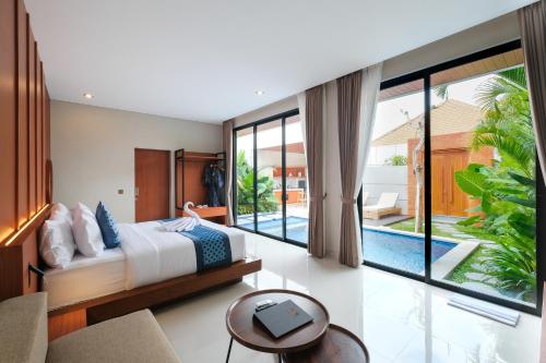 Un dormitorio con una cama y una ventana grande. en Three Brothers Munggu Suites Villas and Restaurant, en Pererenan