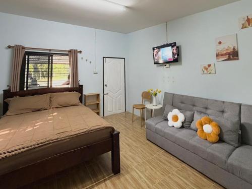 a bedroom with a bed and a couch with two stuffed animals at Krabi Bloom House in Ban Khlong Khamao (2)
