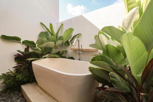 una vasca da bagno in mezzo alle piante di Giegie Villa a Tanah Lot