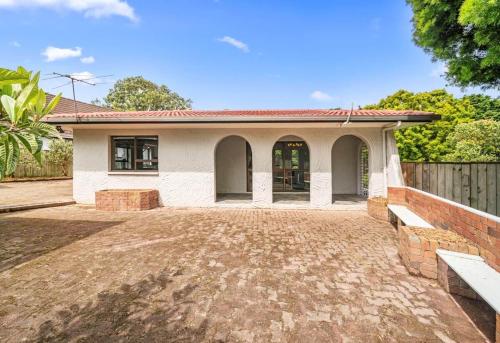 a small white house with a fence in front of it at Spacious 3-Bedroom Retreat Near Airport & City in Auckland