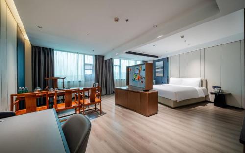 a hotel room with a bed and a television at Atour X Hotel Guangzhou Baiyun International Airport Renhe Station in Guangzhou