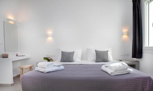 a bedroom with a large bed with two towels on it at Crystal Dream Paros in Ekatondapilianí