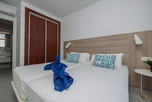 Una gran cama blanca con un arco azul. en Casa Ancoa, en Playa Blanca