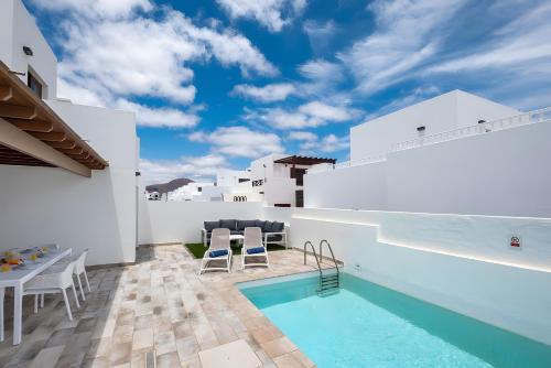 Villa con piscina y paredes blancas en Casa Ancoa, en Playa Blanca